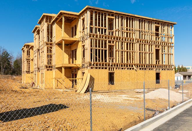 a close-up of temporary chain link fences enclosing a construction site, signaling progress in the project's development in Romulus MI